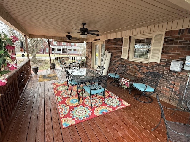 wooden terrace with outdoor dining area and a ceiling fan