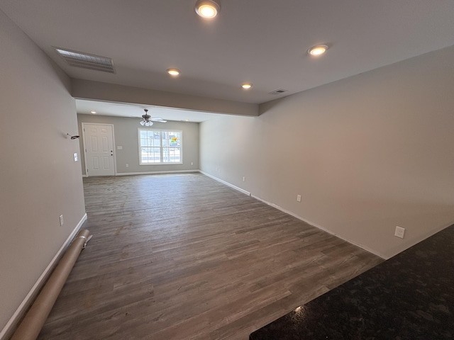 unfurnished room featuring baseboards, visible vents, dark wood-type flooring, and recessed lighting