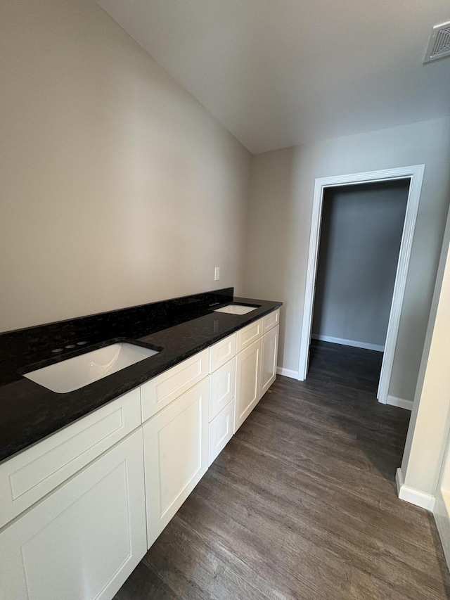 full bathroom featuring wood finished floors, a sink, visible vents, and baseboards