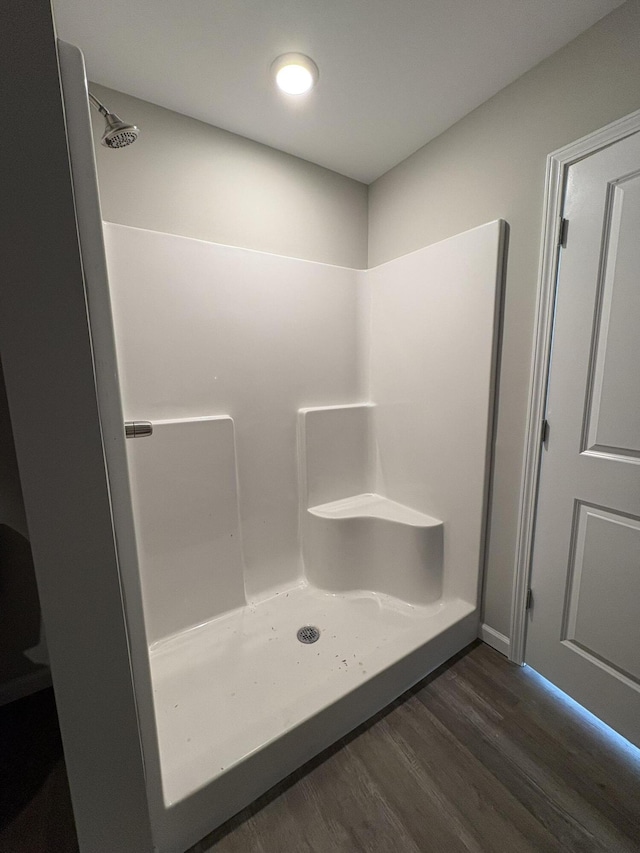 bathroom with a stall shower and wood finished floors