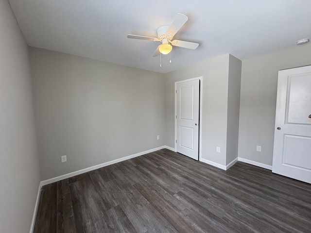 unfurnished bedroom featuring baseboards, dark wood finished floors, and a ceiling fan