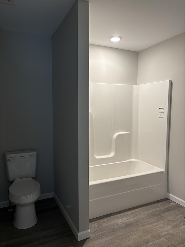 bathroom with toilet, baseboards, and wood finished floors