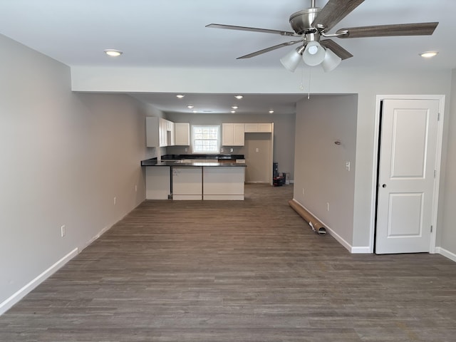 kitchen featuring baseboards, white cabinets, dark countertops, dark wood-style flooring, and recessed lighting