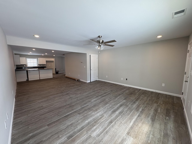 unfurnished living room with a ceiling fan, baseboards, visible vents, and dark wood-type flooring