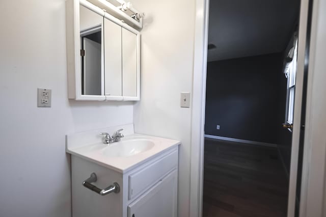 bathroom featuring vanity, baseboards, and wood finished floors