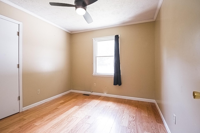 unfurnished room with ornamental molding, baseboards, a textured ceiling, and light wood finished floors