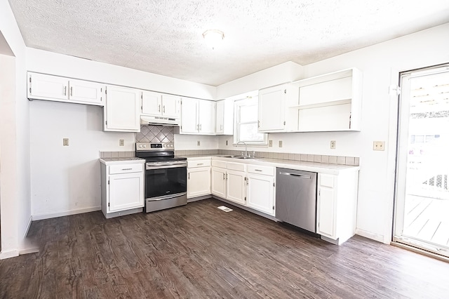 kitchen with open shelves, stainless steel appliances, light countertops, white cabinets, and under cabinet range hood