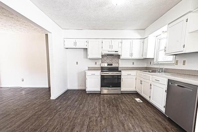 kitchen featuring white cabinets, dark wood-style flooring, stainless steel appliances, under cabinet range hood, and a sink