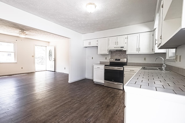 kitchen featuring stainless steel range with electric stovetop, white cabinetry, dark wood-type flooring, and a sink