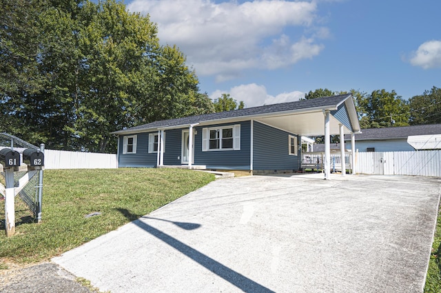 ranch-style house featuring a carport, driveway, a front lawn, and fence