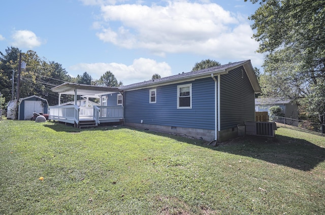 view of front of property with an outbuilding, a front yard, a deck, a shed, and cooling unit