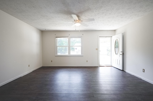 empty room with dark wood-style floors, ceiling fan, a textured ceiling, and baseboards