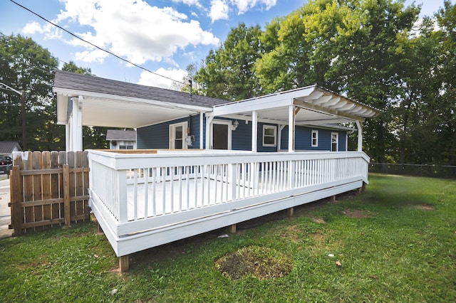 rear view of property with a deck, a lawn, and fence