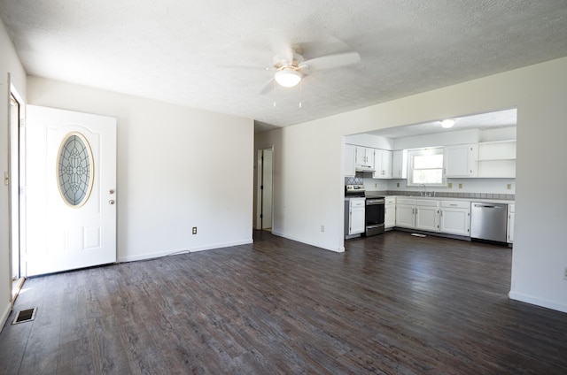 unfurnished living room featuring ceiling fan, dark wood finished floors, a sink, and visible vents