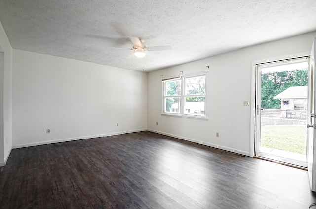 spare room featuring a textured ceiling, dark wood-style flooring, a ceiling fan, and baseboards