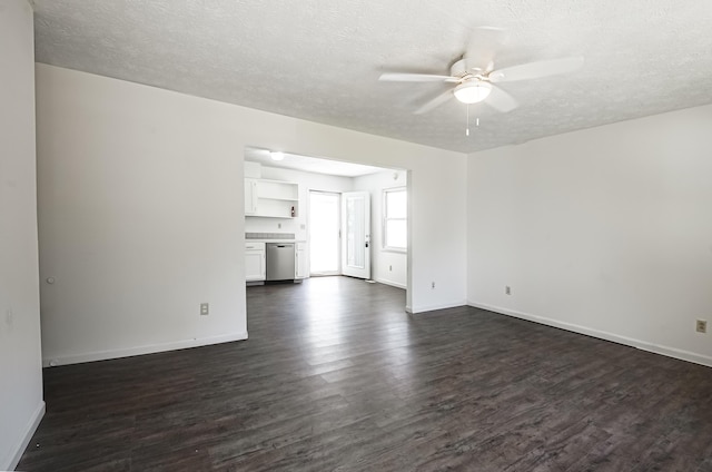 empty room featuring dark wood-type flooring, a textured ceiling, and baseboards