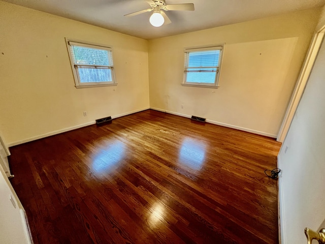 unfurnished bedroom with wood finished floors, baseboards, a ceiling fan, and visible vents