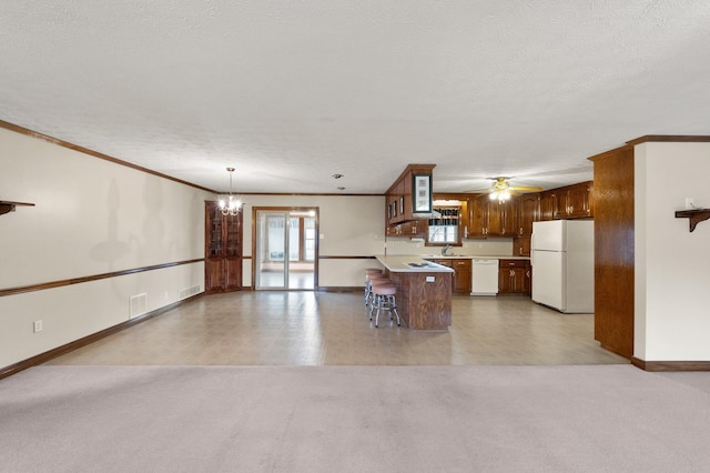 kitchen with a peninsula, light carpet, a healthy amount of sunlight, and white appliances