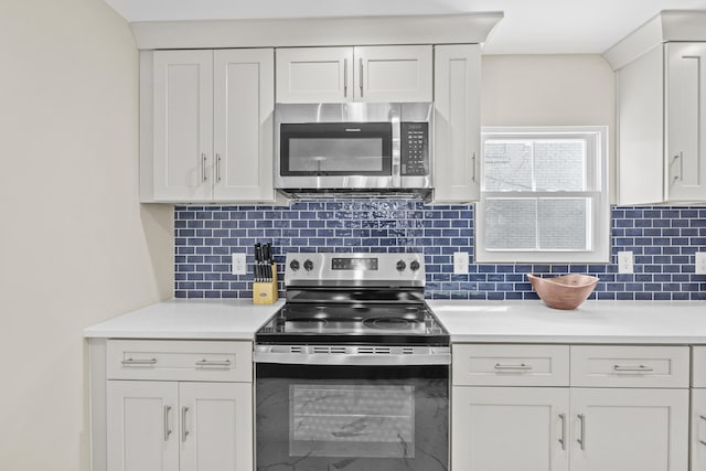 kitchen featuring stainless steel appliances, light countertops, white cabinetry, and tasteful backsplash