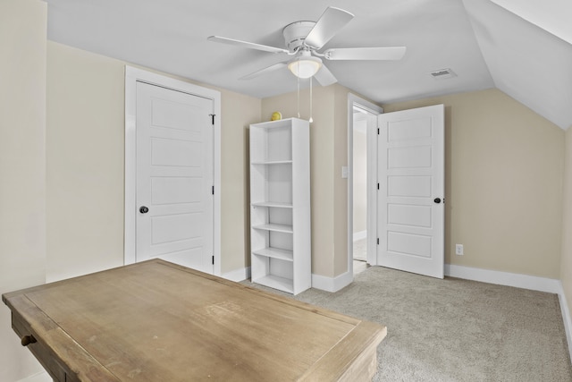 unfurnished bedroom featuring baseboards, visible vents, vaulted ceiling, and light colored carpet