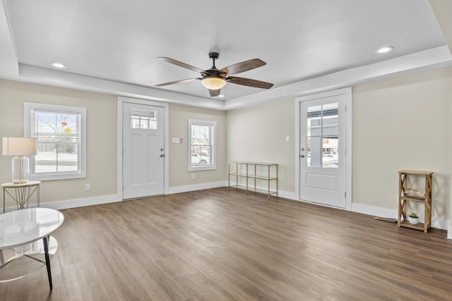 foyer featuring a tray ceiling, dark wood-style flooring, recessed lighting, and baseboards