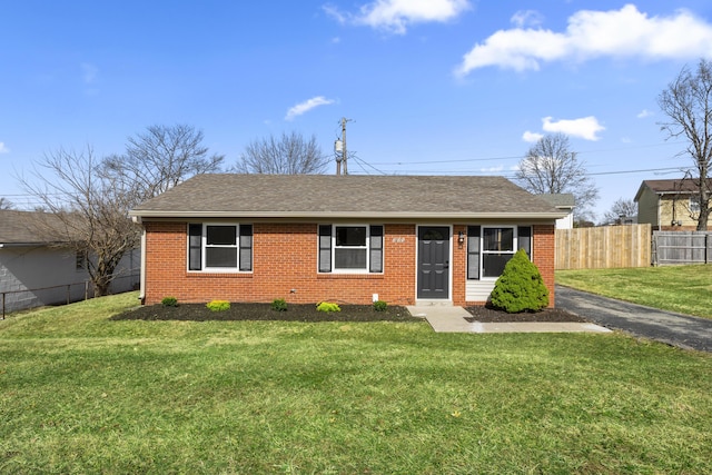 single story home featuring a front yard, fence, and brick siding