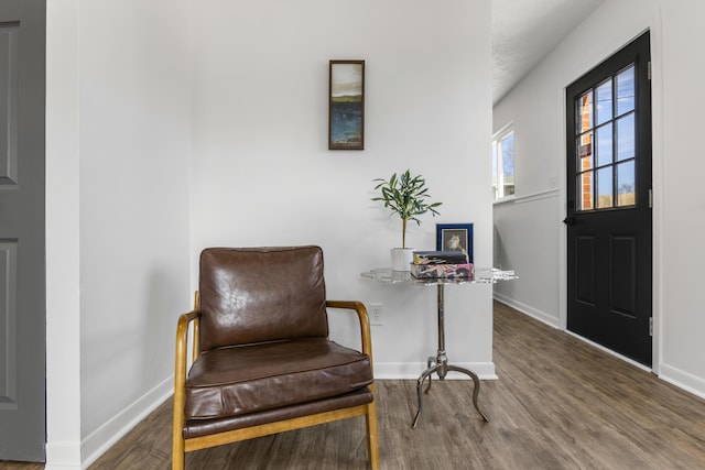 living area with baseboards and wood finished floors