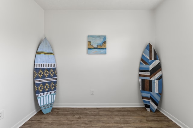 bedroom featuring baseboards and dark wood-type flooring