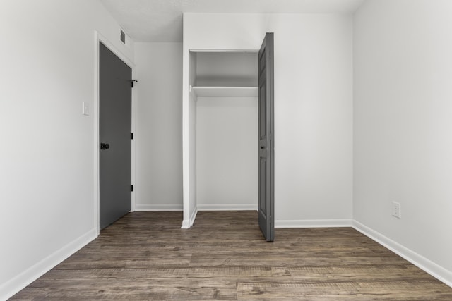 unfurnished bedroom with baseboards, visible vents, and wood finished floors