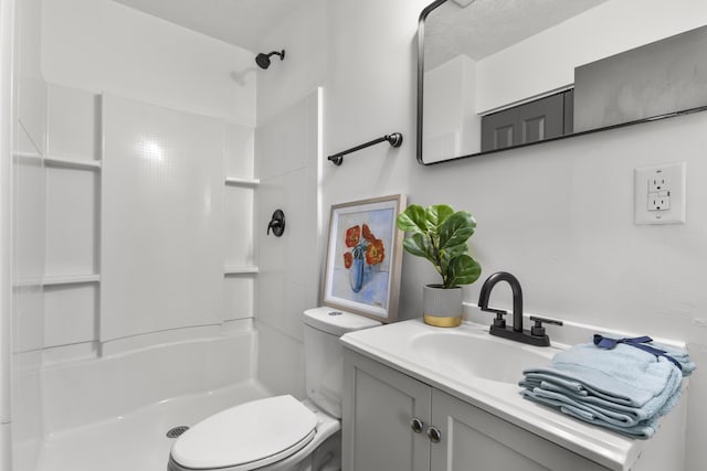 bathroom featuring a shower, vanity, and toilet