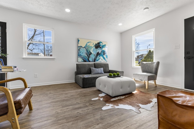 sitting room with recessed lighting, a textured ceiling, baseboards, and wood finished floors