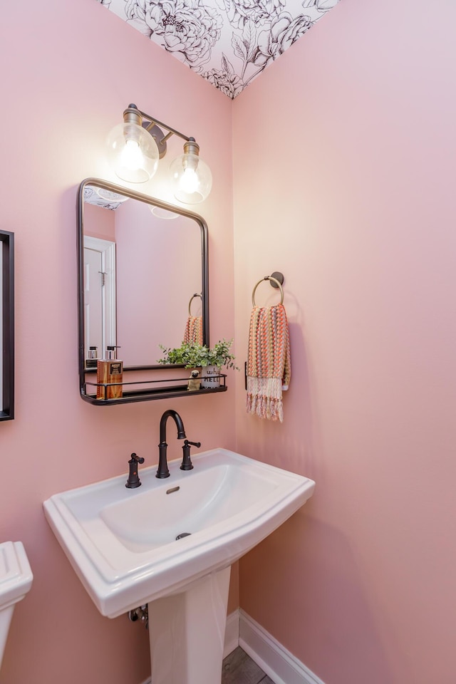 bathroom with a sink and baseboards