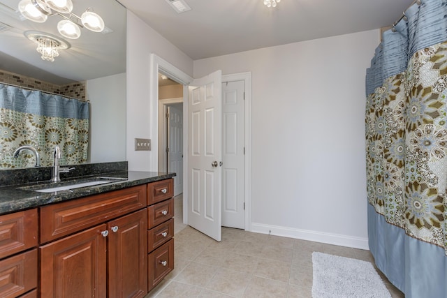 bathroom with tile patterned flooring, a notable chandelier, visible vents, baseboards, and vanity