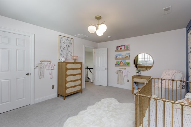 bedroom with a crib, baseboards, visible vents, and light colored carpet