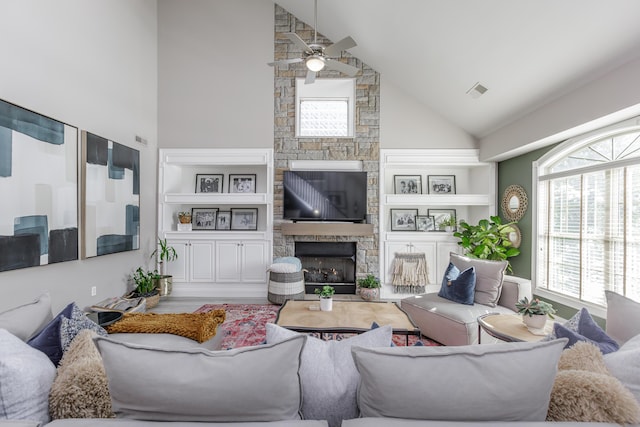 living area featuring high vaulted ceiling, a fireplace, a ceiling fan, and built in features