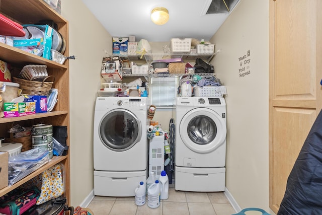 clothes washing area featuring laundry area, tile patterned flooring, baseboards, and washer and clothes dryer