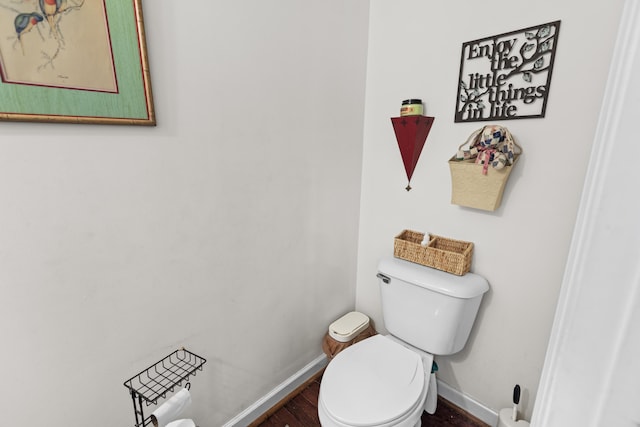 bathroom with toilet, baseboards, and wood finished floors