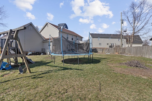 view of yard with a trampoline, a playground, and fence