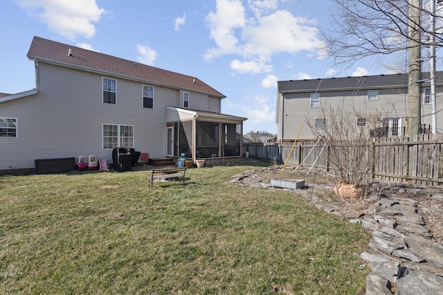 rear view of property featuring a sunroom, a garden, fence, and a lawn