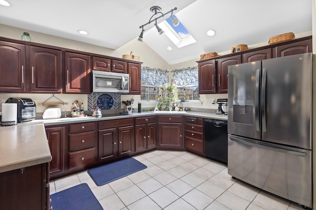 kitchen featuring vaulted ceiling with skylight, light countertops, black appliances, and light tile patterned floors