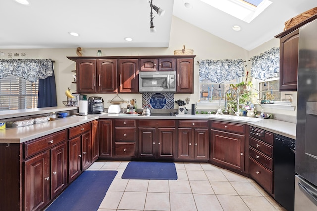 kitchen with vaulted ceiling with skylight, a peninsula, light countertops, dark brown cabinets, and black appliances