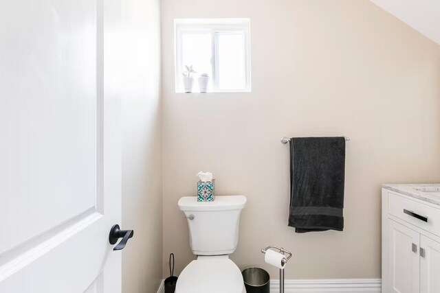 bathroom featuring shower / tub combo, toilet, and baseboards