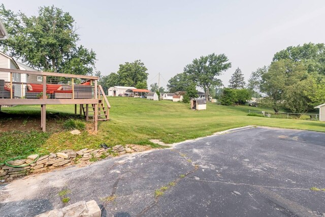 view of front of property with a wooden deck, an attached garage, aphalt driveway, and metal roof