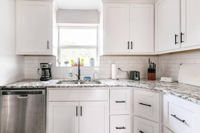 kitchen featuring backsplash, white cabinets, dishwasher, and a sink