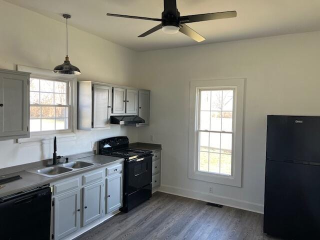 kitchen with a sink, plenty of natural light, black appliances, and under cabinet range hood