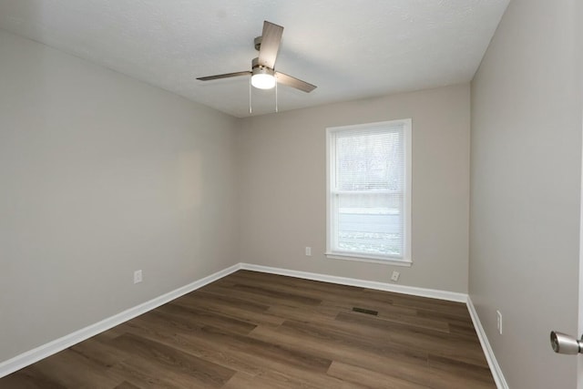 spare room featuring ceiling fan, a textured ceiling, dark wood-style flooring, visible vents, and baseboards