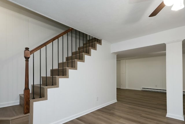 stairs with ceiling fan, baseboards, baseboard heating, and wood finished floors