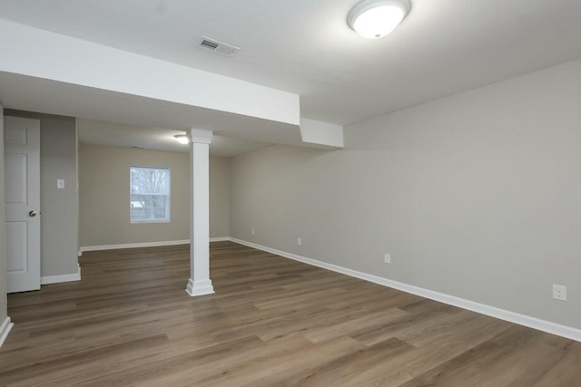 basement featuring wood finished floors, visible vents, and baseboards