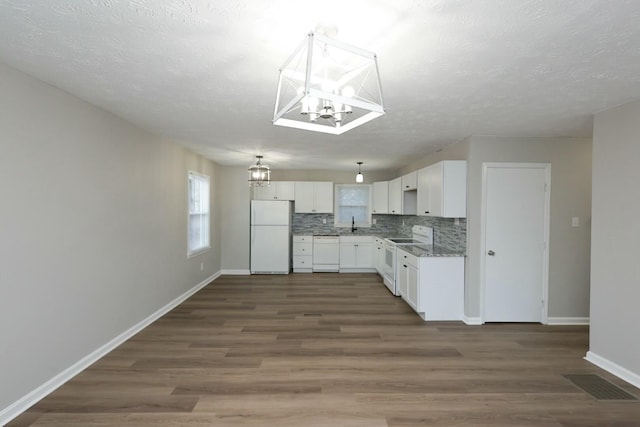 kitchen with a notable chandelier, white appliances, visible vents, white cabinets, and decorative backsplash