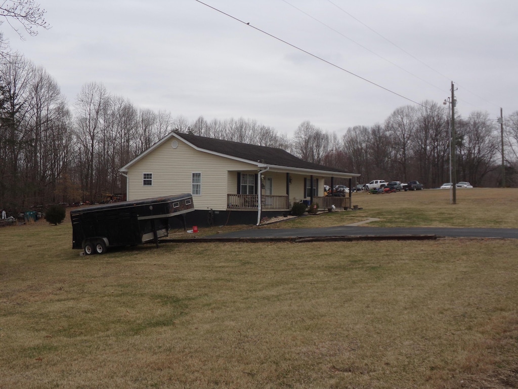 view of home's exterior with covered porch and a yard